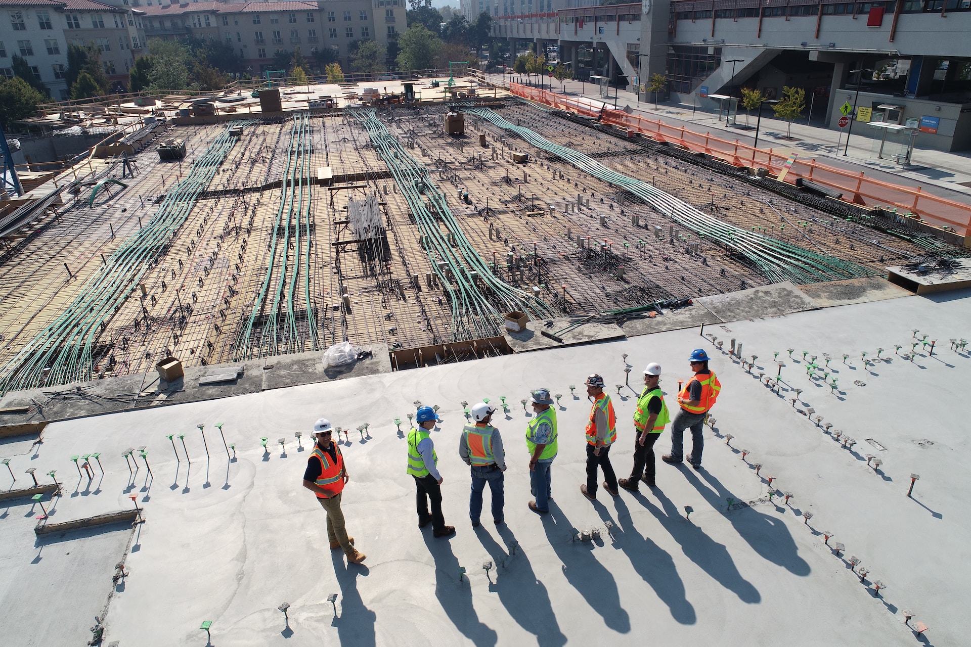 Construction Workers Overseeing a Foundation with Installed Piping and Rebar, Ready for Concrete Pour